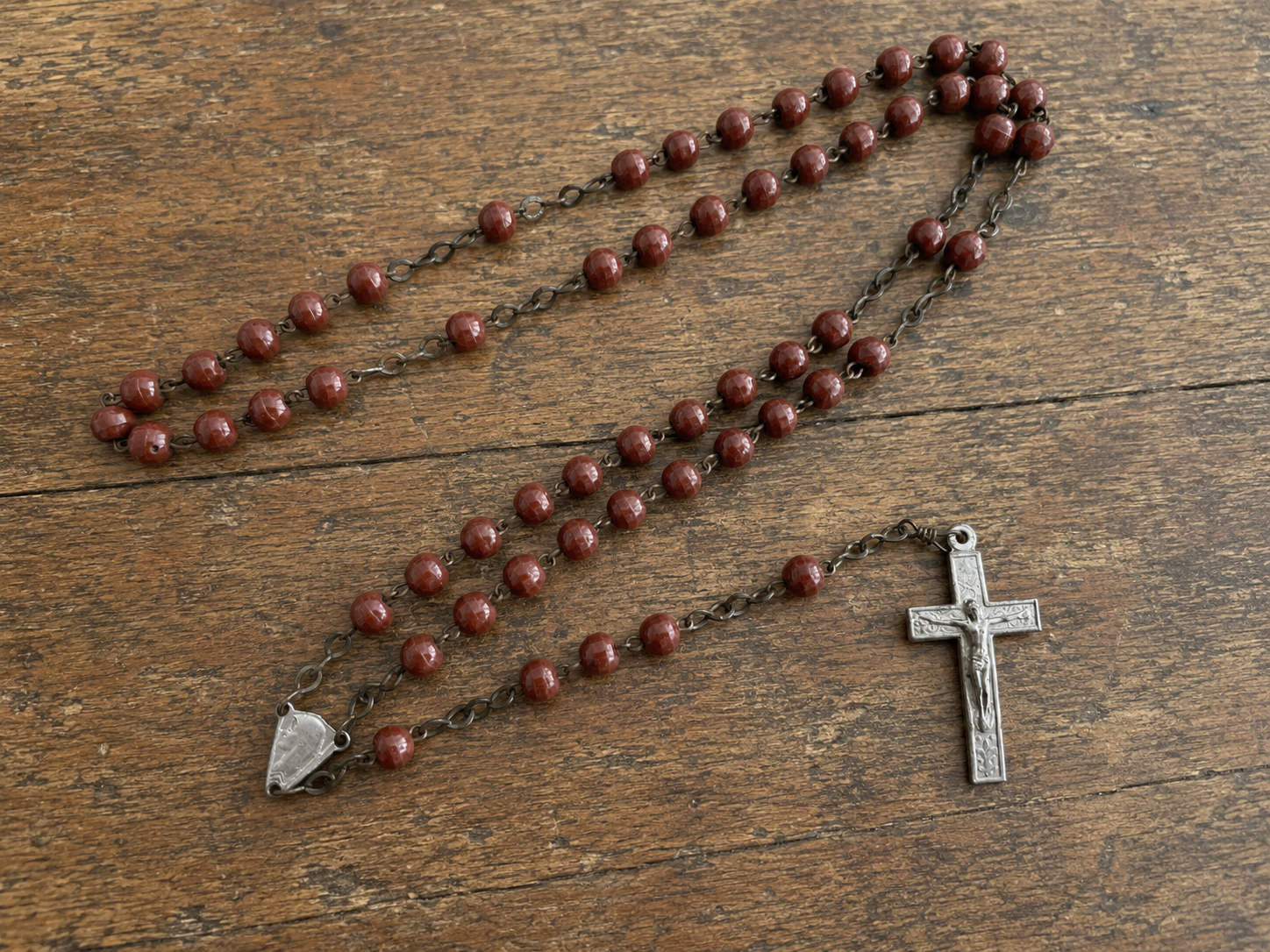Eddie's red-brown rosary on an antique wooden table